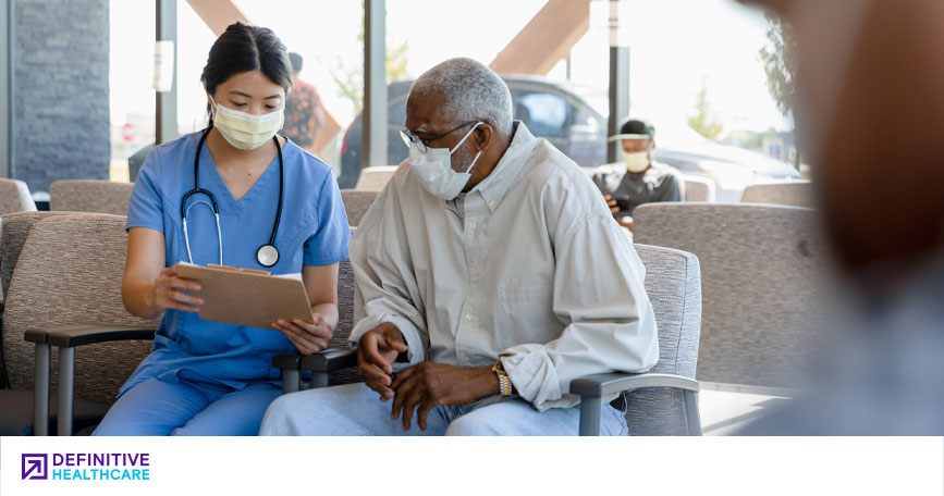 A female healthcare worker reviews a chart with an elderly patient. 