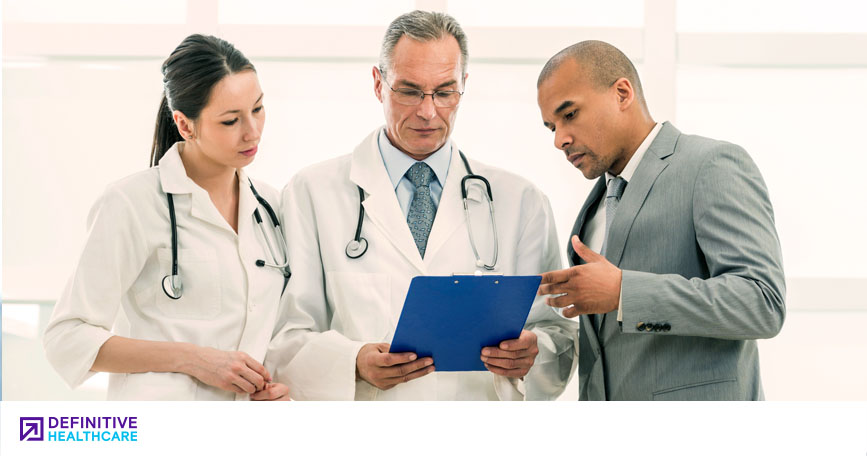 A medical affairs professional reviews a clip board with two healthcare professionals.