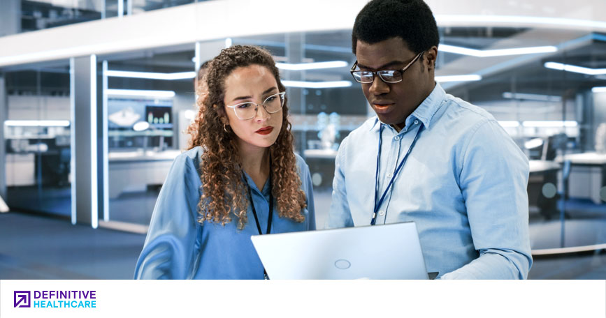 Two business professionals examine a report in an office setting.