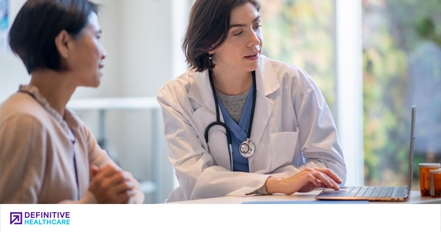 A healthcare professional reviews data on a laptop with a patient.