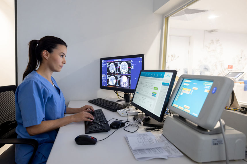 Radiologist looking at x-rays and patient data on computer screens