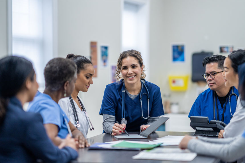 A group of healthcare professionals sit around a table.