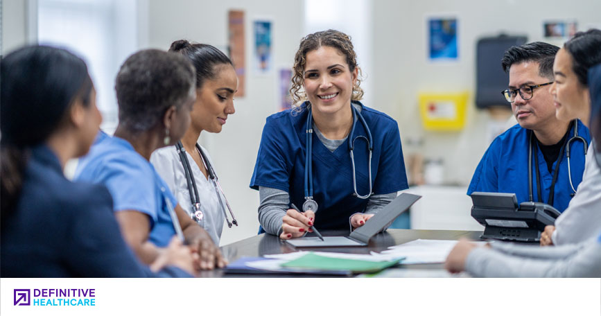 A group of healthcare professionals sit around a table.