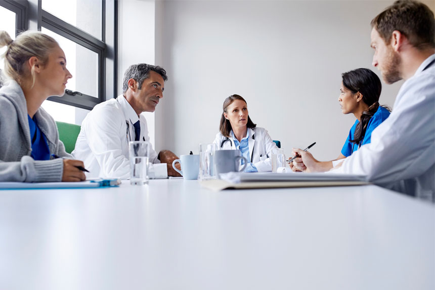 A group of healthcare professionals sit around a table.