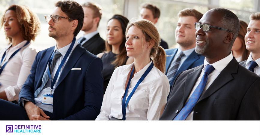 A divers group of people in business attire sitting attentively 