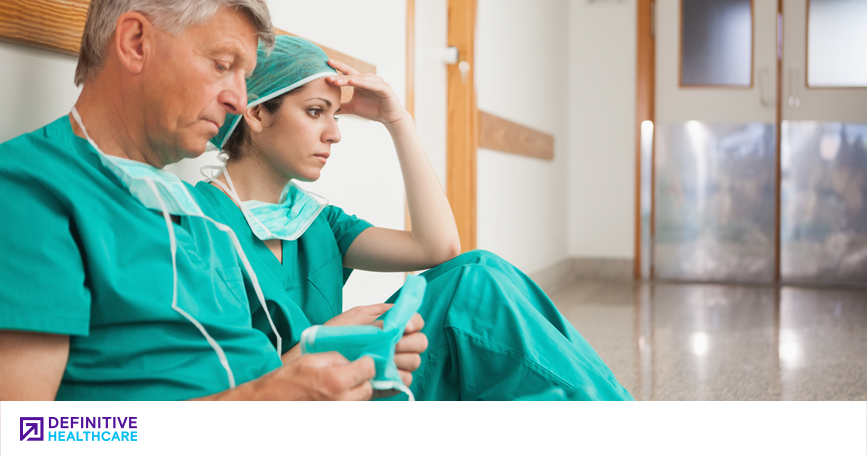 Emotionally exhausted physicians sitting in a hospital hallway