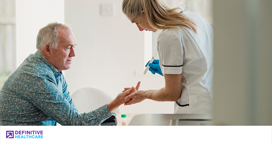 An older man getting his blood drawn from his finger by a healthcare professional