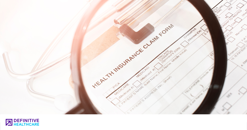 A magnifying glass looking at a healthcare claims form