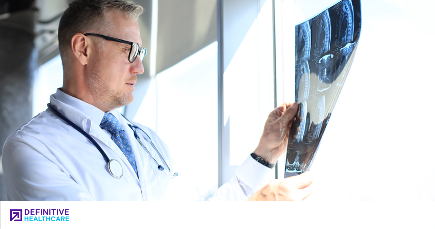 A clinician examines an x-ray image.